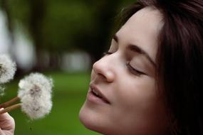 girl with dandelions close-up on a blurred background