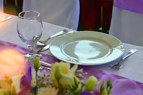 Settings on the wedding table with beautiful and colorful flowers, among the chairs