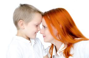 Smiling, blonde kid boy, with the mother with orange hair, together