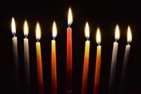 Colorful, burning candles with candlelight, among the darkness