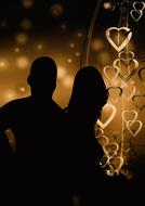 silhouette of a couple in love on a background of golden hearts