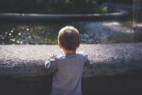 little boy looking at the fountain