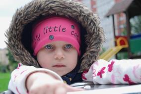 little girl in a pink hat on the playground