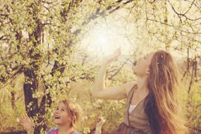 mother and daughter under a flowering tree