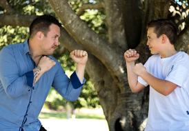 father and son fight under a big tree