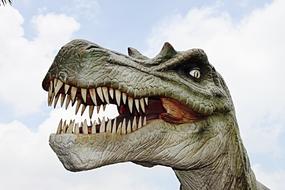 Colorful figure of a dinosaur, under the blue sky with white clouds