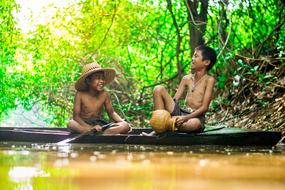 boys on a boat in asia nature