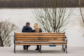 couple in love on a bench near the lake in winter