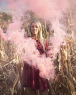 girl in pink smoke on the field