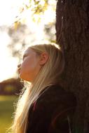 blonde near a tree on a blurred background
