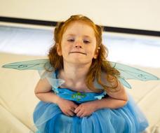 Portrait of the cute, smiling girl in the beautiful and colorful fairy costume