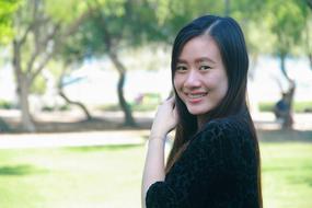 asian girl with dark hair on a blurred nature background