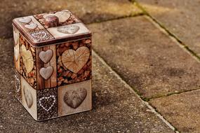 Box with colorful collage with heart shapes, on the pavement