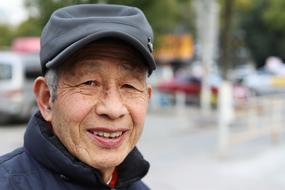 Portrait of the smiling man in cap, outdoors