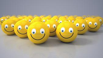 yellow balls in the form of emoticons on a gray surface