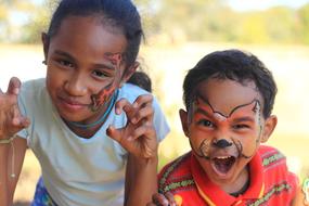 happy kids with drawings on their faces on a blurred background