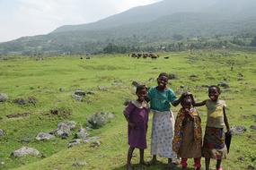 People on the beautiful landscape with colorful animals, green grass and rocks near the mountains, in Kenya, Africa