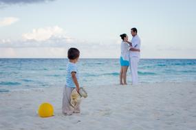 family resting on the beach by the sea