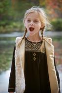 surprised girl with pigtails on a blurred background of nature