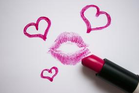 Beautiful, purple and pink lipstick painting of hearts and kiss print, on the white surface