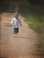 Boy Walking on Dirt Road