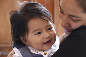 Portrait of the cute baby girl in the hands of the mother