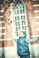 boy throwing autumn leaves up