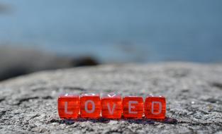 the inscription loved on red cubes on the stone