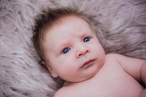 baby with blue eyes on a warm blanket