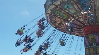 people ride a carousel in an amusement park