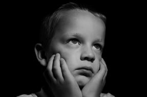 portrait of a sad child on a black background