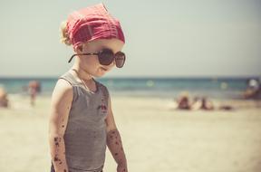 stylish little kid on the beach on a sunny day