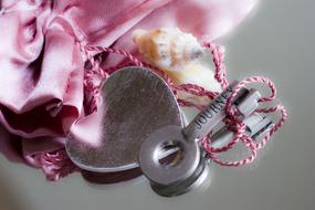 metal heart with a key on a pink bag