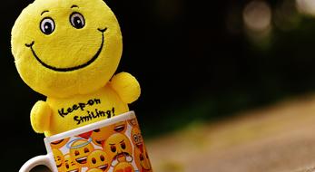 Beautiful and cute, yellow and black smiley dog in the cup with smilies