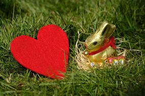 easter bunny next to red heart on green grass