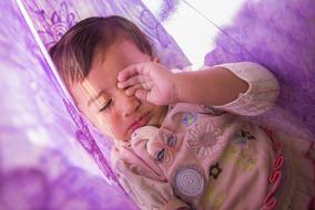 Cute Baby Girl slips on purple blanket