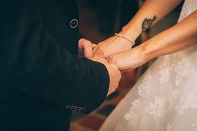 Groom and bride with tattoo, holding hands on the wedding