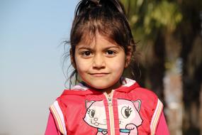 little girl with ponytail smiling