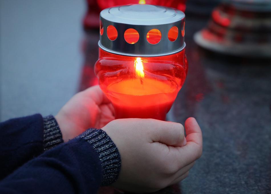 mourning candle in the hands of a child
