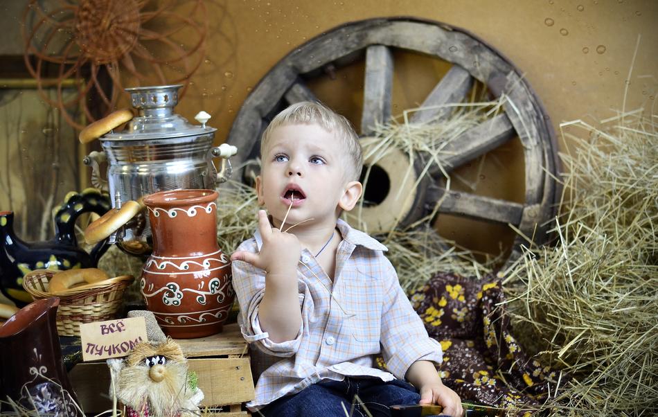 photo of a boy on the background of rural utensils
