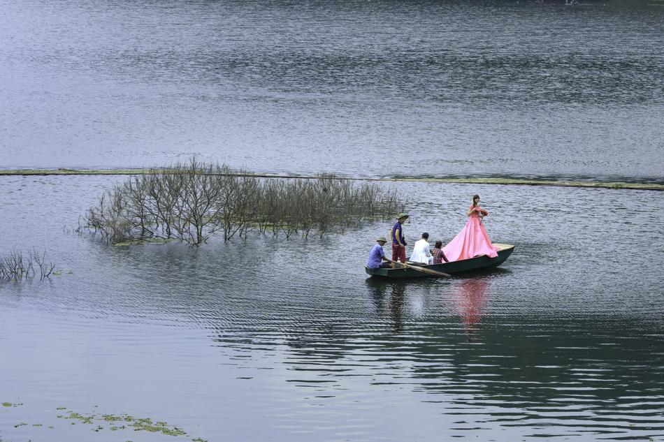 the bride and groom are sailing on a boat on the lake