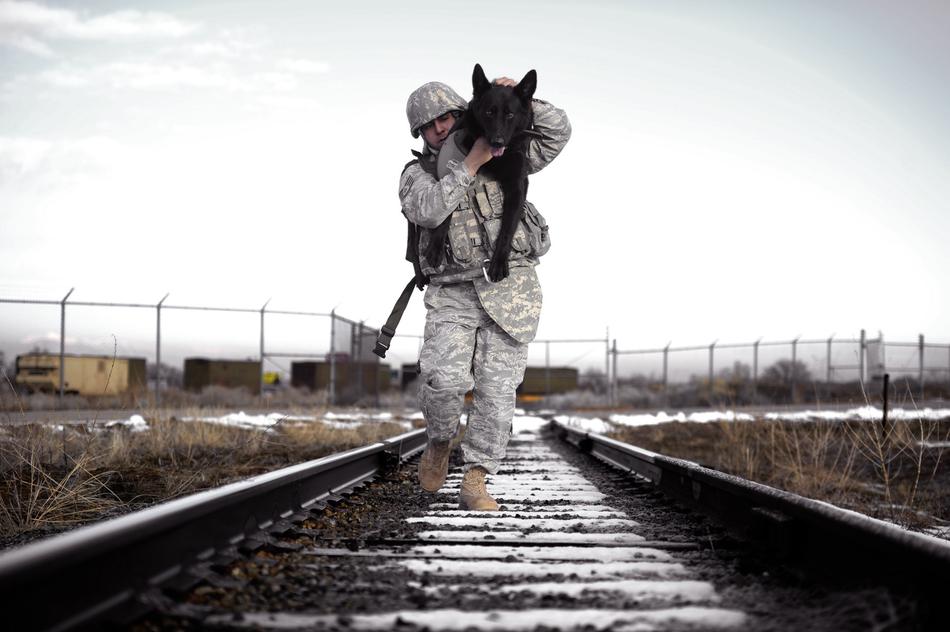 soldier walking with dog on shoulder at winter