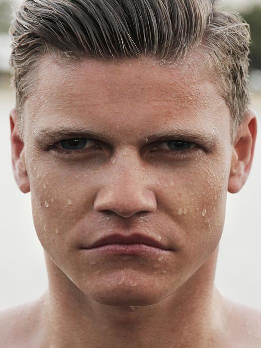 Portrait of a cute, wet, frowning male with blonde hair