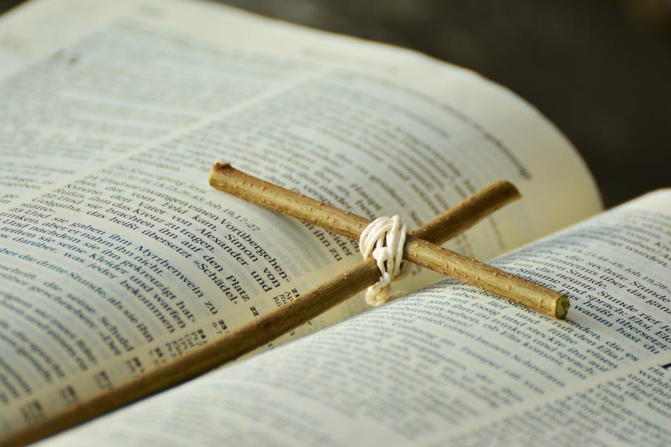 wooden cross lies on holy scripture