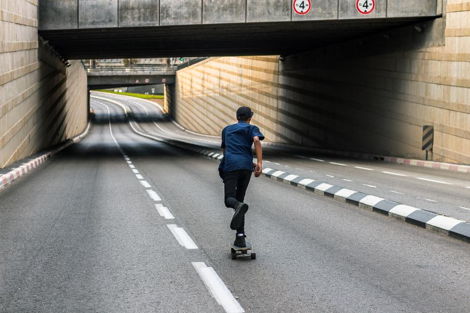 roller Skating on road beneath bridge