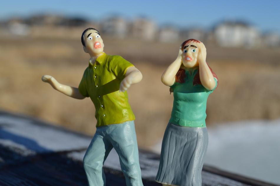 figurines of a frightened man and woman on a blurred background