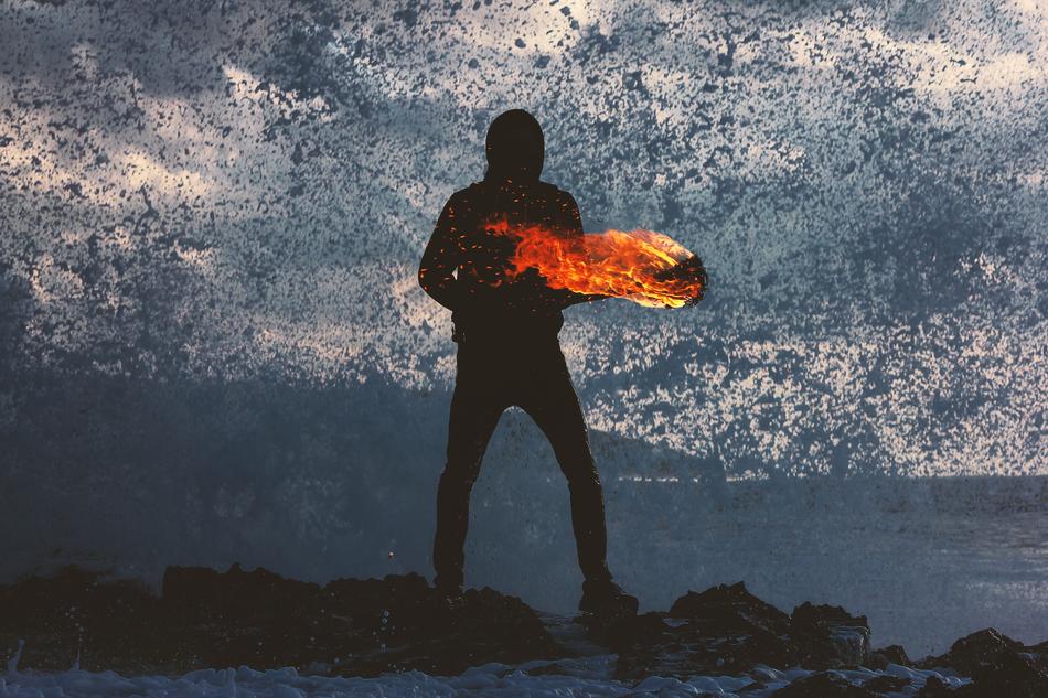 Black silhouette of a person and fire, on the beautiful landscape of the beach