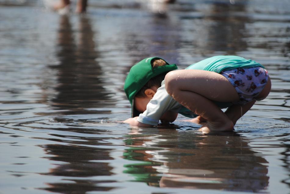 kid playing in the water in summer