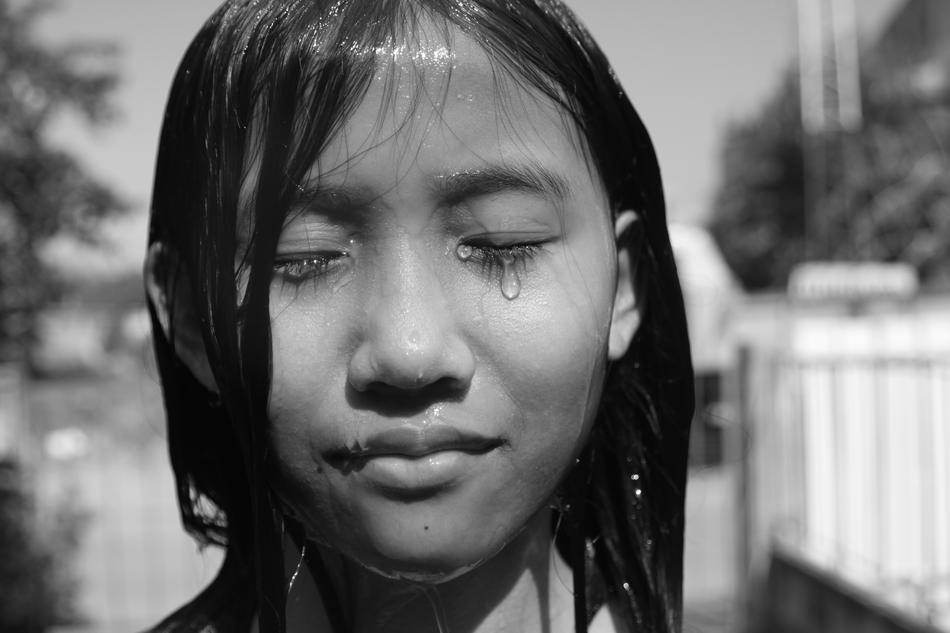 Black and white photo, with the portrait of the wet, crying girl