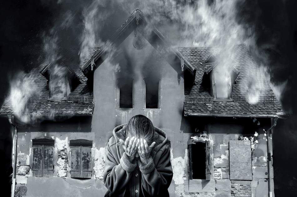 black and white photo of burning house Smoke and sad man